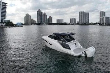 Slide: The Image of 2025 NX Boats NX360 Sport Coupe on water with city skyline backdrop. - 4