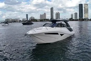 Slide: The Image of 2025 NX Boats NX360 Sport Coupe cruising near city skyline on a sunny day. - 5