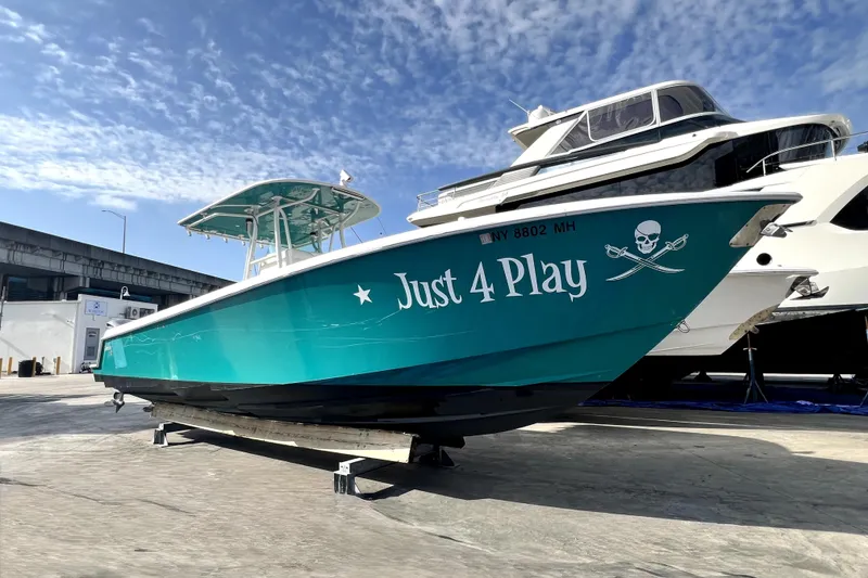 The Image of 2012 Contender 35 LS boat named "Just 4 Play" on display under a clear sky. - 0