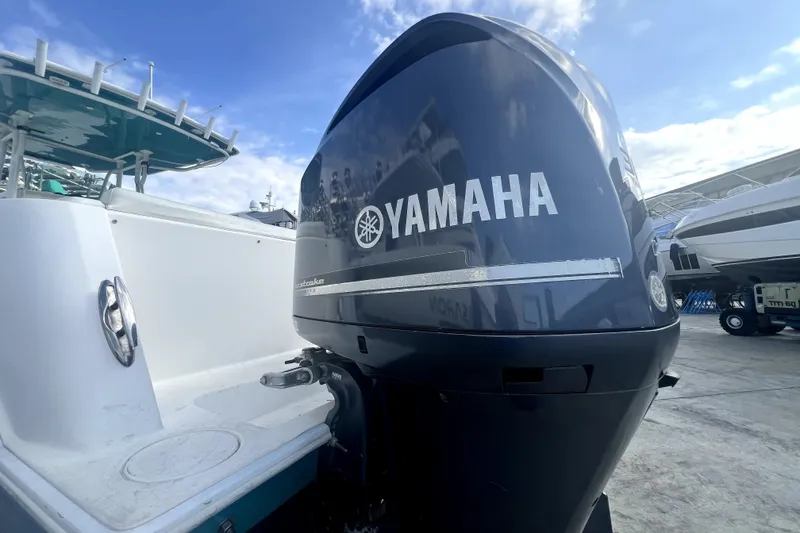 Slide: The Image of 2012 Contender 35 LS boat with Yamaha outboard motor, docked under a clear sky. - 16