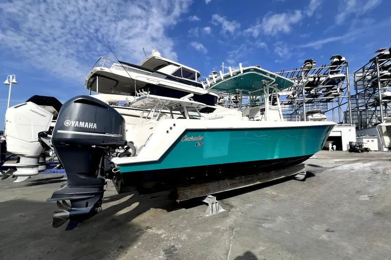 Slide: The Image of 2012 Contender 35 LS boat with Yamaha outboard motor, docked under a clear blue sky. - 2