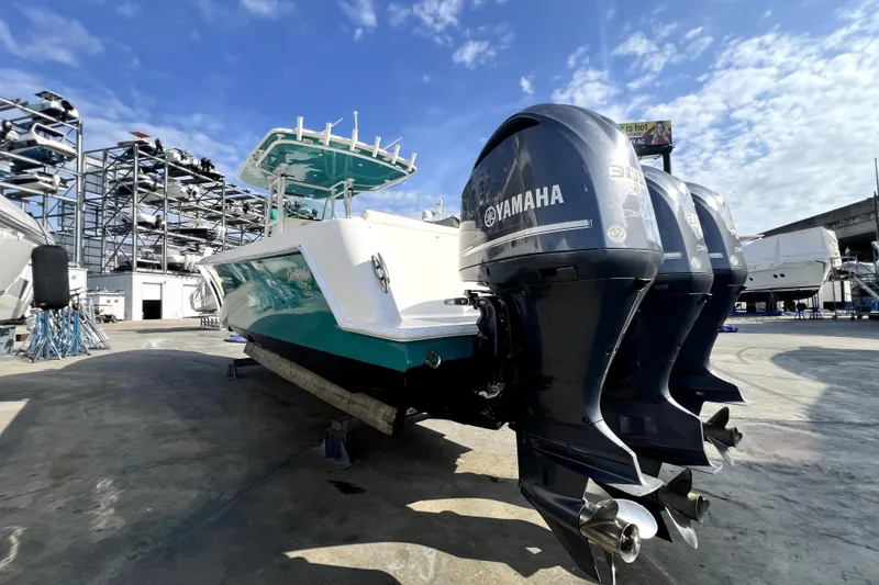 Slide: The Image of 2012 Contender 35 LS boat with triple Yamaha engines in a marina setting. - 21