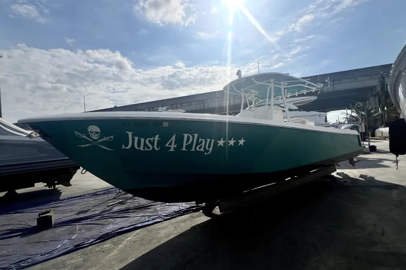 Slide: The Image of 2012 Contender 35 LS boat named "Just 4 Play" docked under a sunny sky. - 24