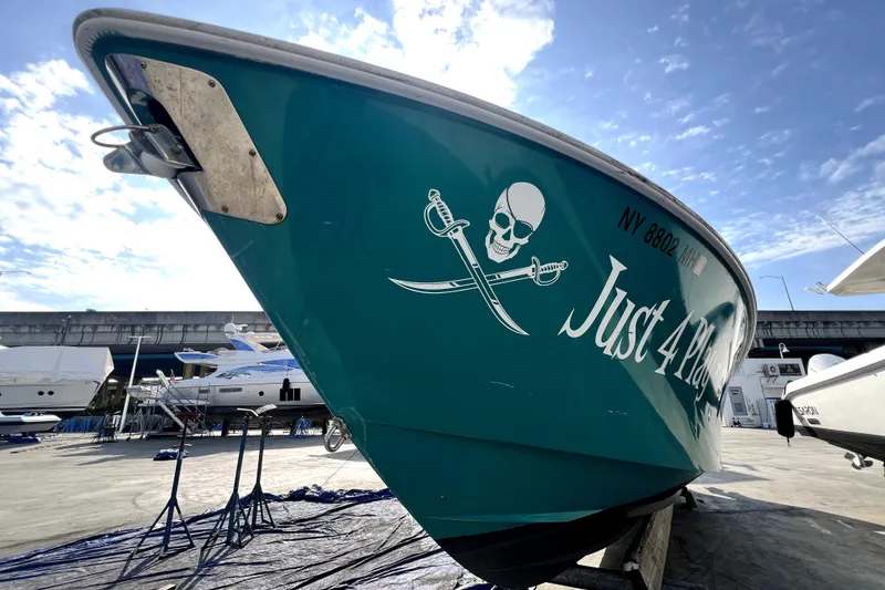 Slide: The Image of 2012 Contender 35 LS boat with pirate-themed graphics, docked under a clear sky. - 25
