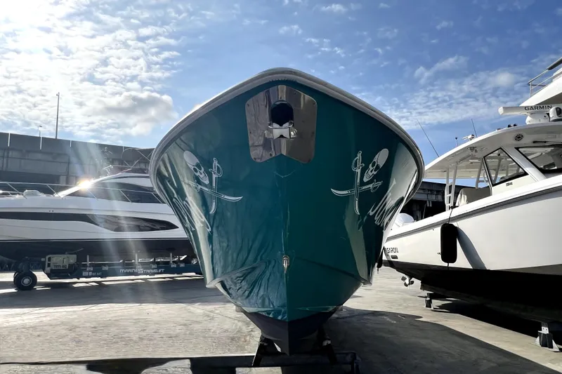 Slide: The Image of 2012 Contender 35 LS boat with skull design, docked under a sunny sky. - 27