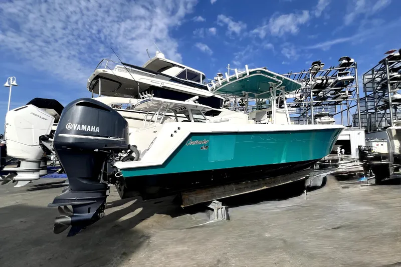 Slide: The Image of 2012 Contender 35 LS boat with Yamaha engine, docked under clear blue sky. - 3