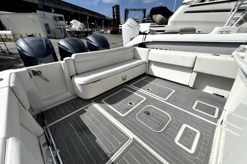 Slide: The Image of 2012 Contender 35 LS boat interior with cushioned seating and outboard motors. - 34