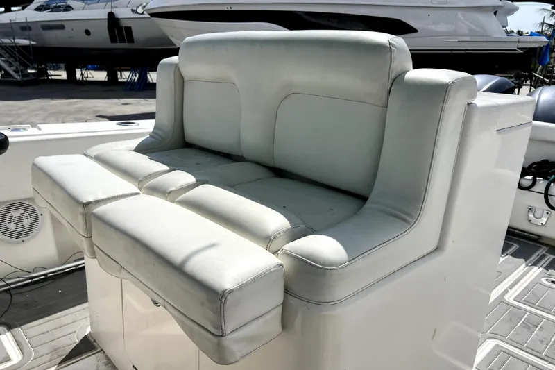 Slide: The Image of White leather seating on a 2012 Contender 35 LS boat, docked with other vessels. - 36