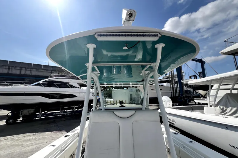 Slide: The Image of 2012 Contender 35 LS boat with teal canopy, docked under a sunny sky. - 46