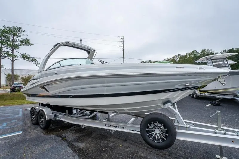Slide: The Image of 2026 Crowline 290 XSS boat on trailer, parked outdoors. - 2