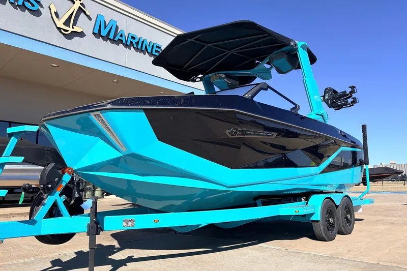 Slide: The Image of 2026 Nautique Super Air Nautique G23 boat in vibrant blue on trailer outside dealership. - 2