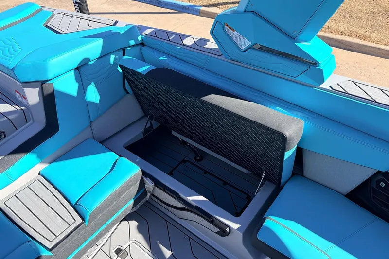 Slide: The Image of 2026 Nautique Super Air Nautique G23 interior with blue seating and open storage compartment. - 34