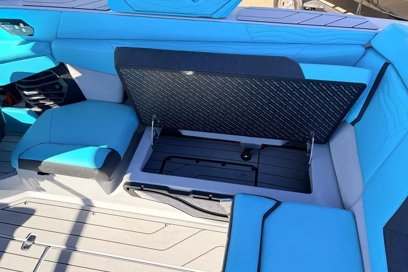 Slide: The Image of 2026 Nautique Super Air Nautique G23 interior with blue seating and open storage compartment. - 42