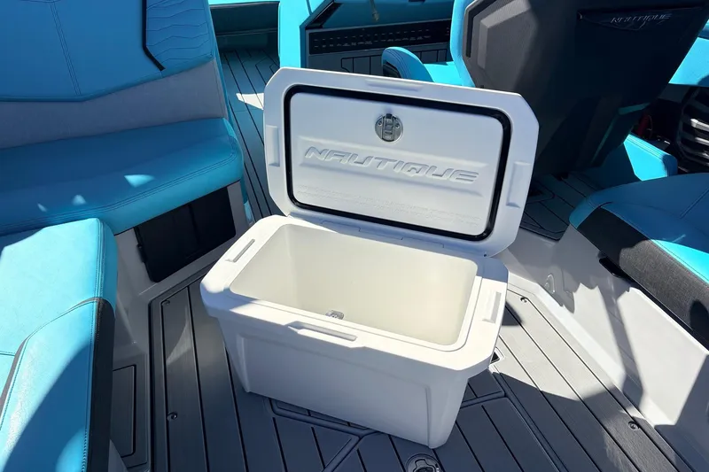 Slide: The Image of Open cooler on 2026 Nautique Super Air Nautique G23 boat with blue seating. - 61