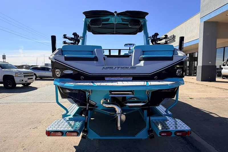 Slide: The Image of 2026 Nautique Super Air Nautique G23 boat, rear view, vibrant blue and white design. - 7