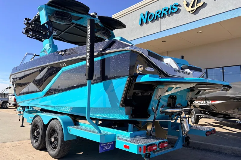Slide: The Image of 2026 Nautique Super Air Nautique G23 boat in vibrant blue at Norris Marine dealership. - 8
