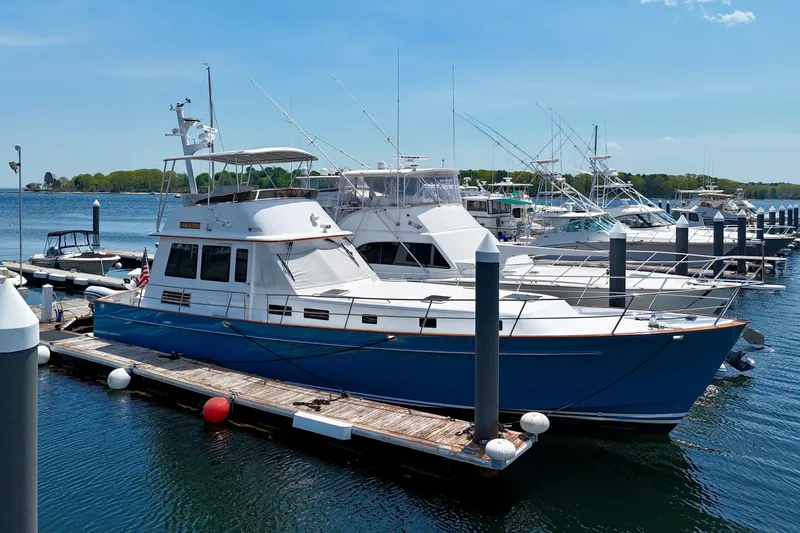 Slide: The Image of A 2002 Legacy 52 yacht docked at a marina on a sunny day. - 1