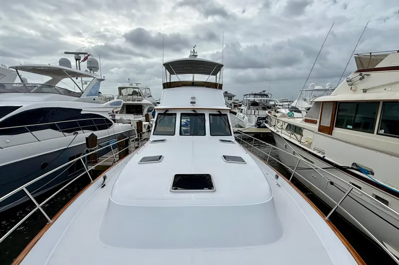 Slide: The Image of 2002 Legacy 52 yacht docked among other boats under cloudy skies. - 10