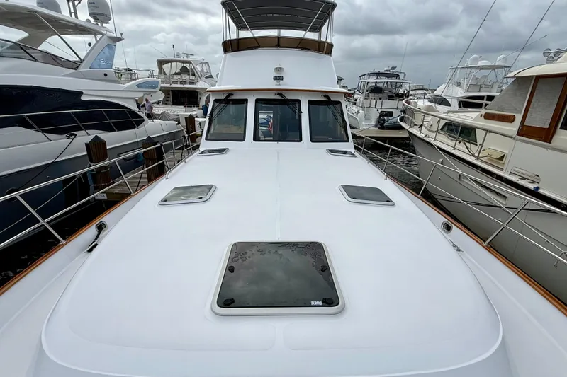 Slide: The Image of 2002 Legacy 52 yacht docked among other boats under cloudy skies. - 11
