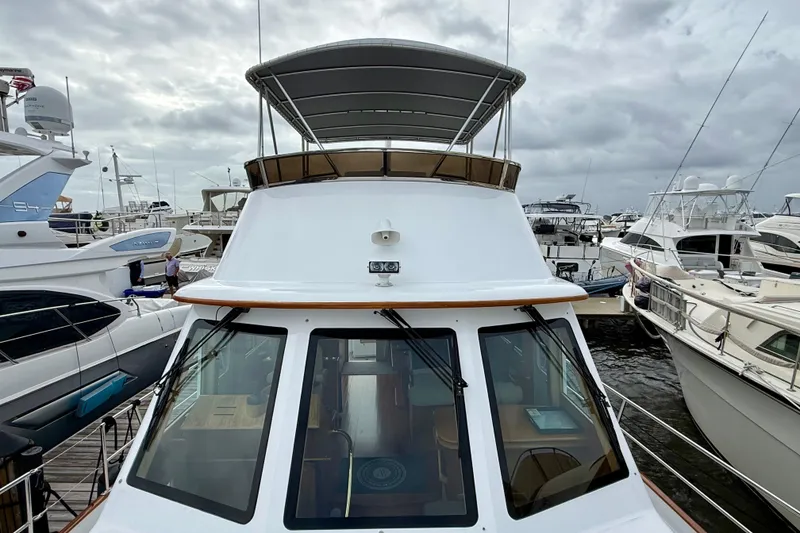 Slide: The Image of 2002 Legacy 52 yacht docked at a marina, surrounded by other boats under cloudy skies. - 12