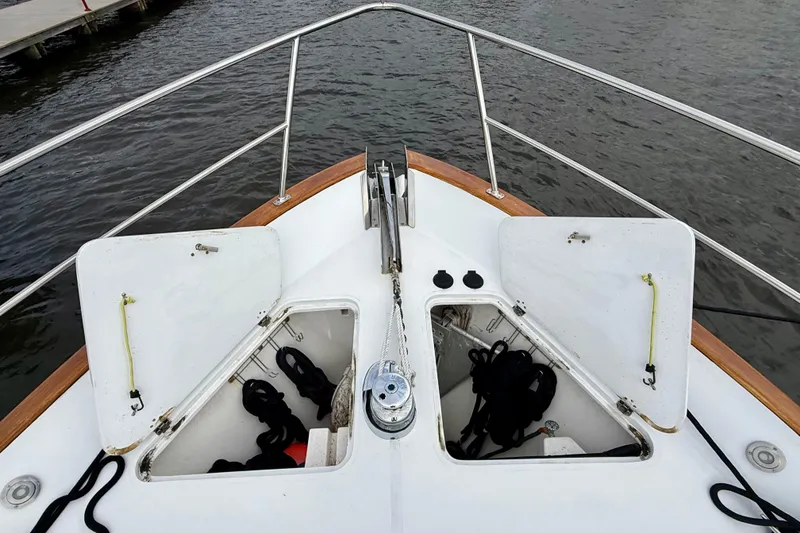 Slide: The Image of Bow of 2002 Legacy 52 boat with open storage compartments and anchor chain. - 14