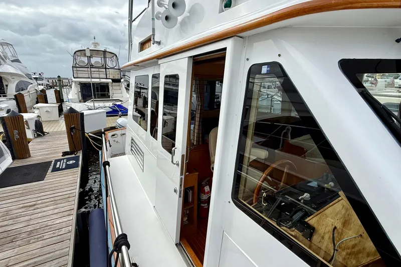 Slide: The Image of Docked 2002 Legacy 52 yacht with wooden accents and visible interior controls. - 16