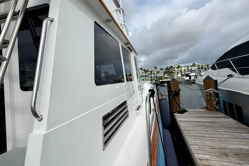 Slide: The Image of Side view of a 2002 Legacy 52 yacht docked at a marina under cloudy skies. - 18