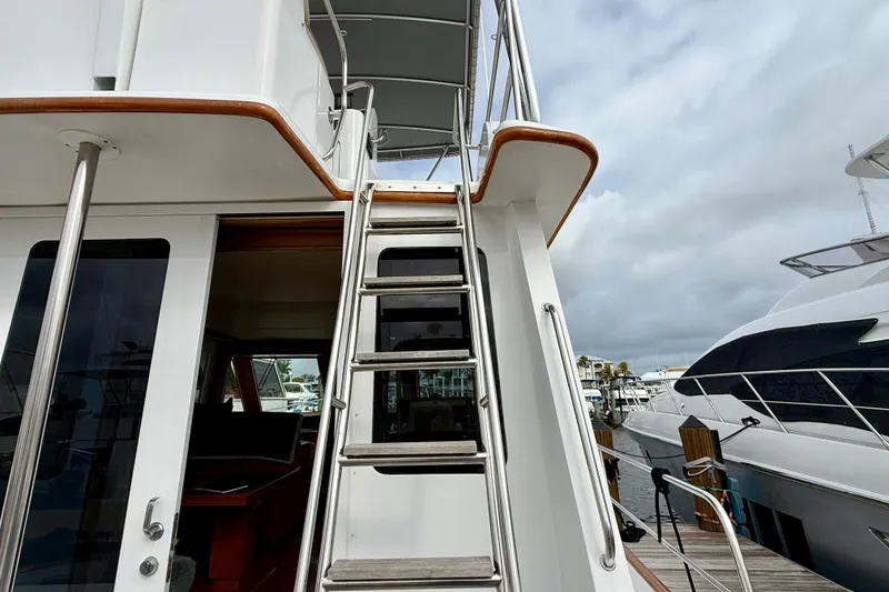 Slide: The Image of Staircase on a 2002 Legacy 52 yacht, docked at a marina under cloudy skies. - 19