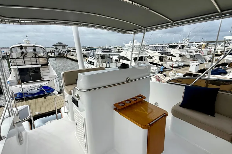 Slide: The Image of 2002 Legacy 52 yacht interior with marina view, featuring seating and helm station. - 24
