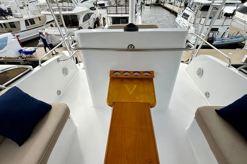 Slide: The Image of Deck view of a 2002 Legacy 52 yacht, featuring seating and a wooden table. - 26