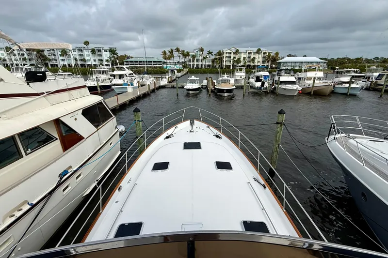 Slide: The Image of Bow view of a 2002 Legacy 52 yacht docked in a marina with surrounding boats. - 27