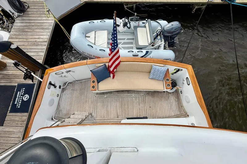 Slide: The Image of Deck view of a 2002 Legacy 52 yacht with American flag and tender boat. - 28