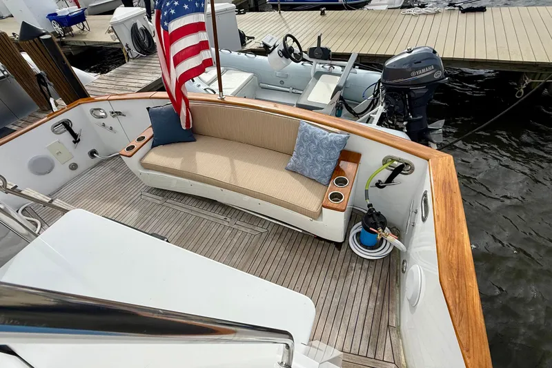 Slide: The Image of Luxurious 2002 Legacy 52 yacht deck with seating, American flag, and Yamaha motor at dock. - 31