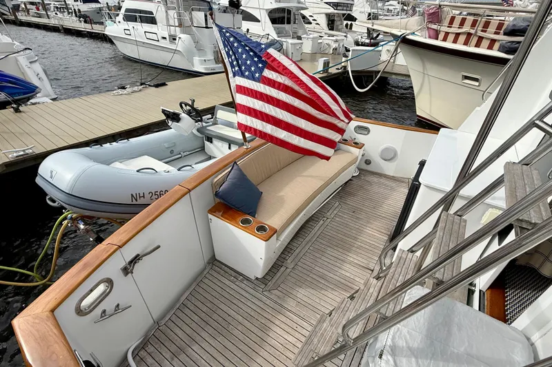 Slide: The Image of Deck of 2002 Legacy 52 yacht with American flag and docked inflatable boat. - 32