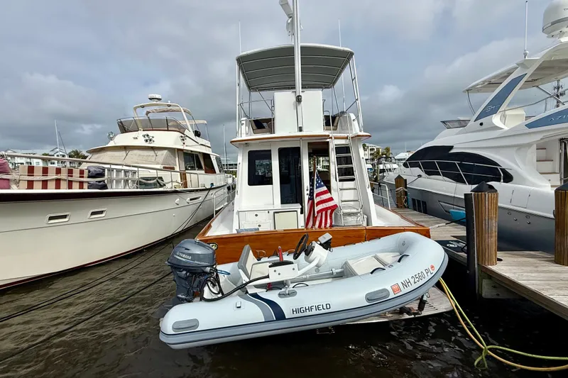Slide: The Image of Legacy 52 yacht from 2002 docked with inflatable boat, American flag displayed. - 4