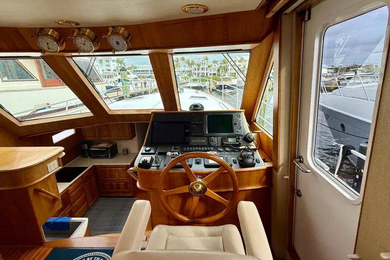 Slide: The Image of Interior view of a 2002 Legacy 52 yacht helm with wooden steering wheel and navigation equipment. - 40