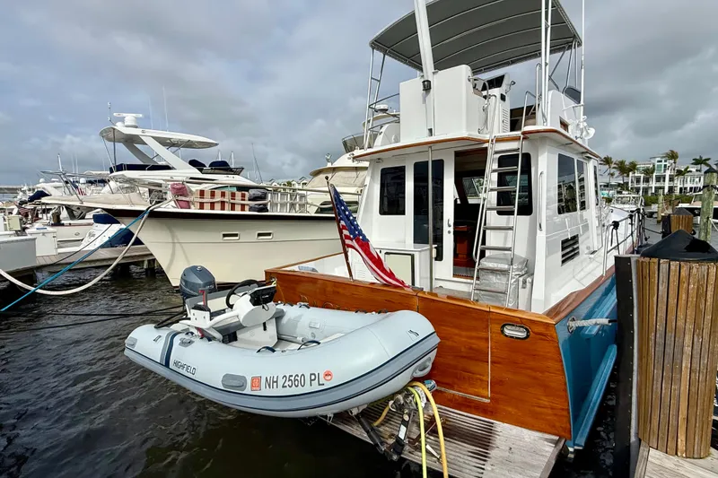 Slide: The Image of Legacy 52 yacht from 2002 docked with inflatable boat, American flag displayed. - 5