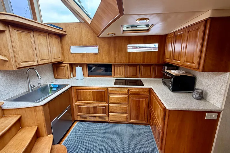 Slide: The Image of Luxurious 2002 Legacy 52 yacht kitchen with wooden cabinetry and modern appliances. - 51