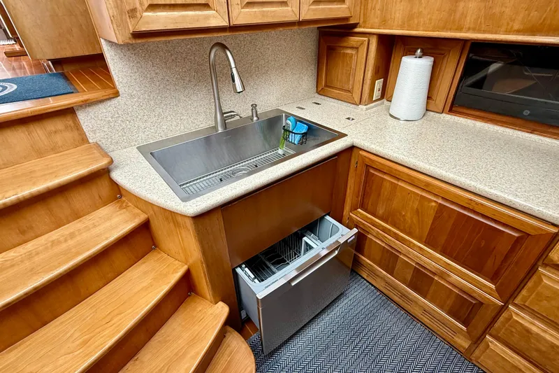 Slide: The Image of Legacy 52 yacht kitchen with wooden cabinetry, stainless steel sink, and dishwasher, 2002 model. - 52