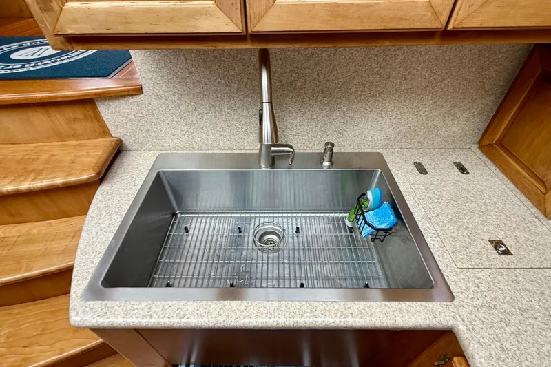 Slide: The Image of Stainless steel sink in a 2002 Legacy 52 yacht kitchen with wooden cabinetry. - 53