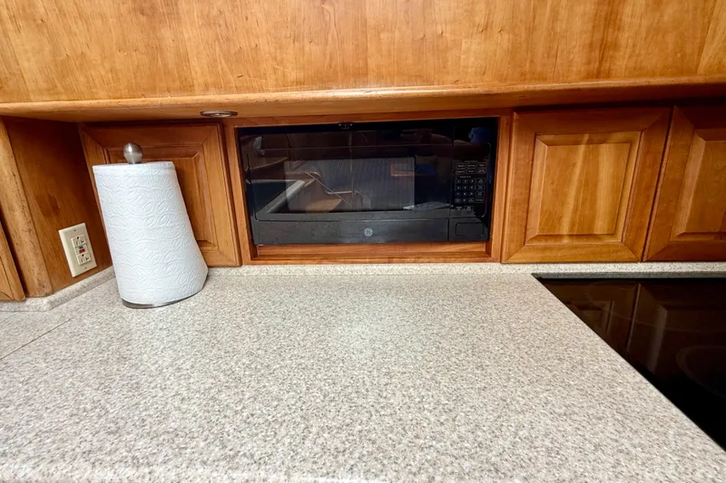 Slide: The Image of Kitchen countertop with paper towel holder, built-in microwave, and wooden cabinets in a Legacy 52, 2002. - 56