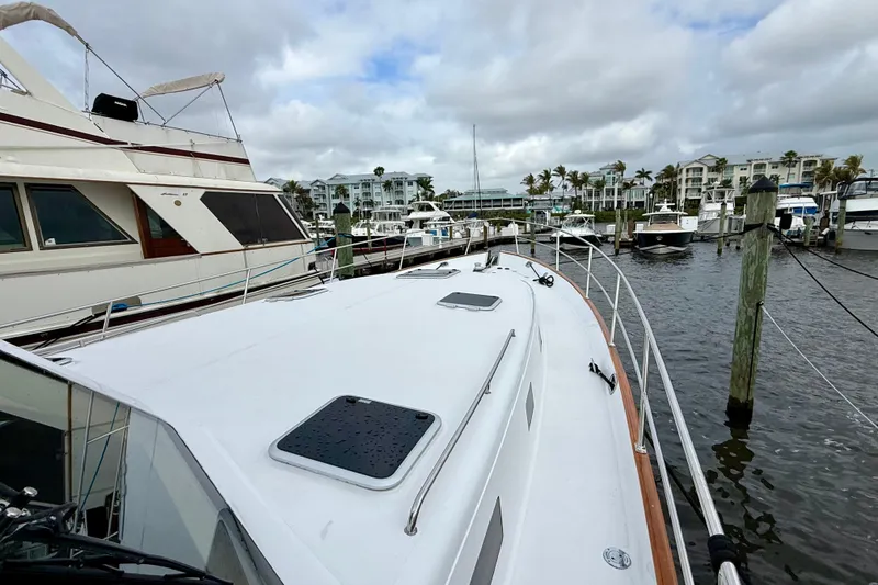 Slide: The Image of 2002 Legacy 52 yacht docked at marina with surrounding boats and cloudy sky. - 6