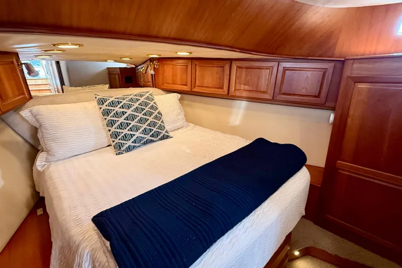 Slide: The Image of Cozy bedroom in 2002 Legacy 52 yacht with wooden cabinets and elegant bedding. - 63