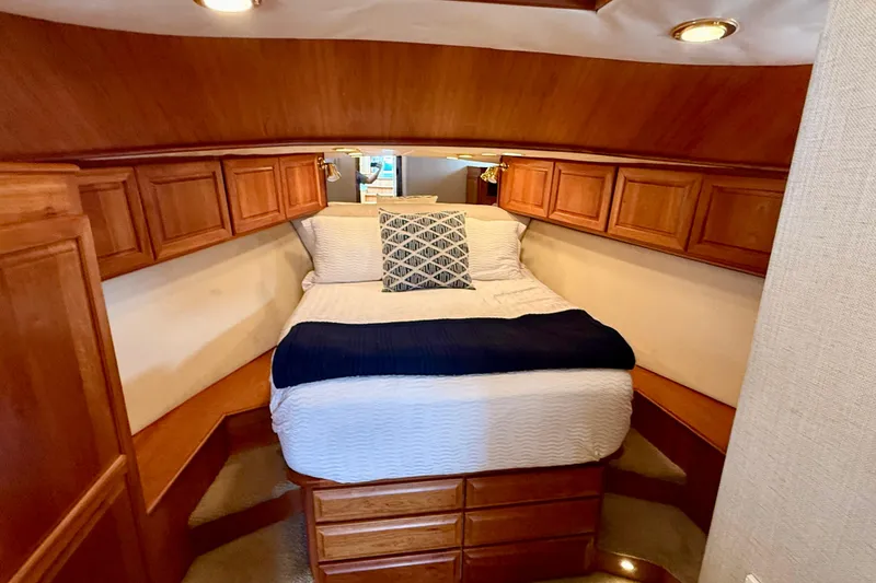 Slide: The Image of Cozy cabin bedroom in 2002 Legacy 52 yacht with wooden cabinetry and plush bedding. - 64