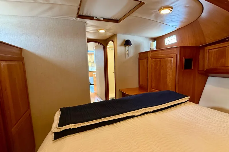 Slide: The Image of Luxurious cabin interior of a 2002 Legacy 52 yacht with wooden furnishings and cozy bedding. - 65