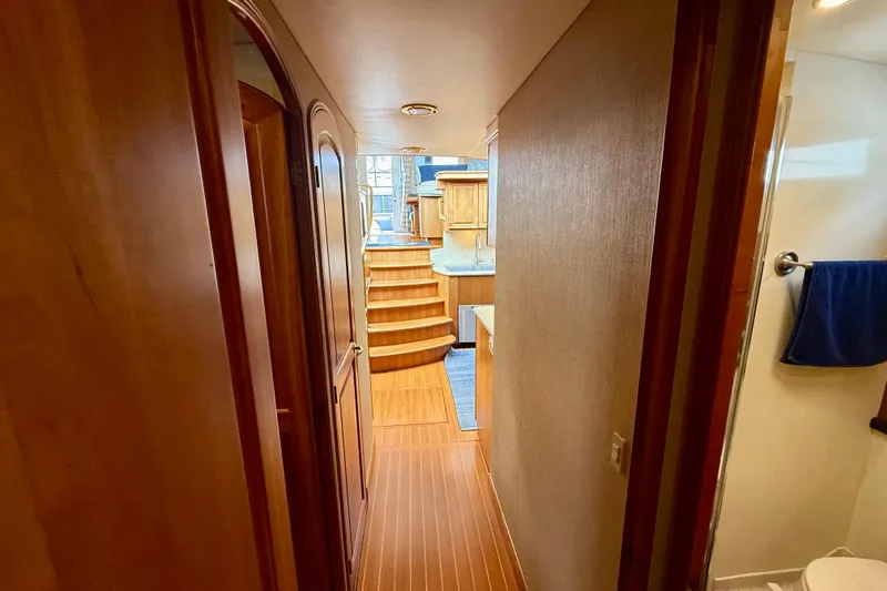 Slide: The Image of Hallway inside 2002 Legacy 52 yacht, featuring wooden flooring and steps leading to kitchen. - 67