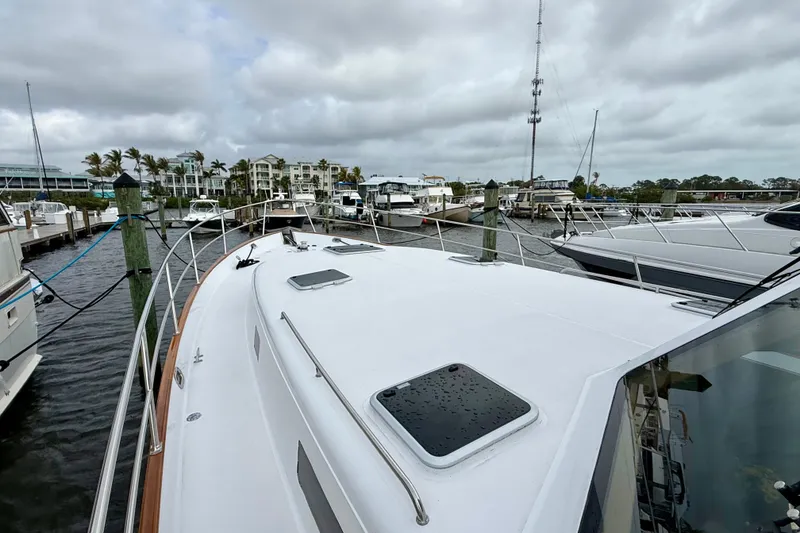 Slide: The Image of 2002 Legacy 52 yacht docked at marina with cloudy sky backdrop. - 7
