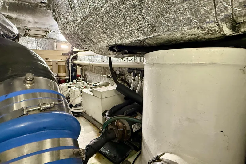 Slide: The Image of Engine room of a 2002 Legacy 52 yacht, showcasing machinery and insulated pipes. - 73