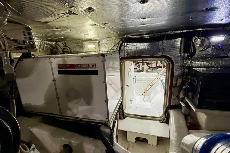 Slide: The Image of Engine room of a 2002 Legacy 52 yacht with generator set and insulated walls. - 74