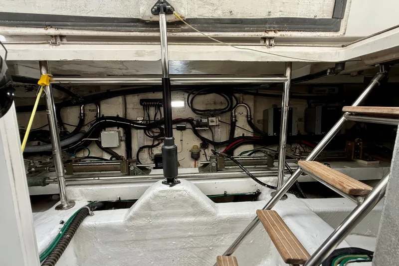 Slide: The Image of Engine room of a 2002 Legacy 52 boat, featuring mechanical components and access ladder. - 75